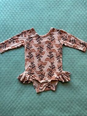 Kate Quinn ruffle leg long sleeve bodysuit